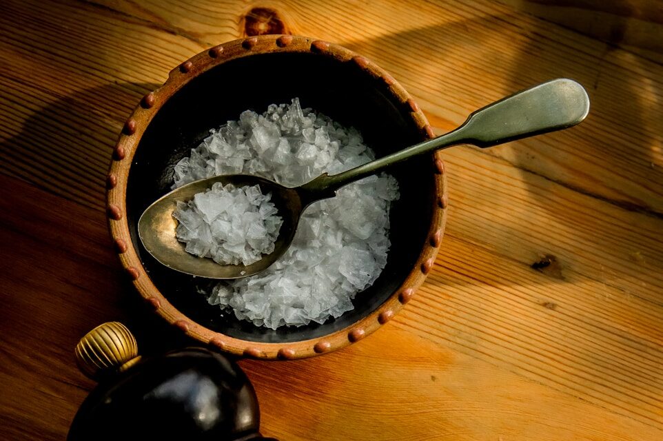 Photo by Luwadlin Bosman a wooden bowl filled with white rice next to a bottle